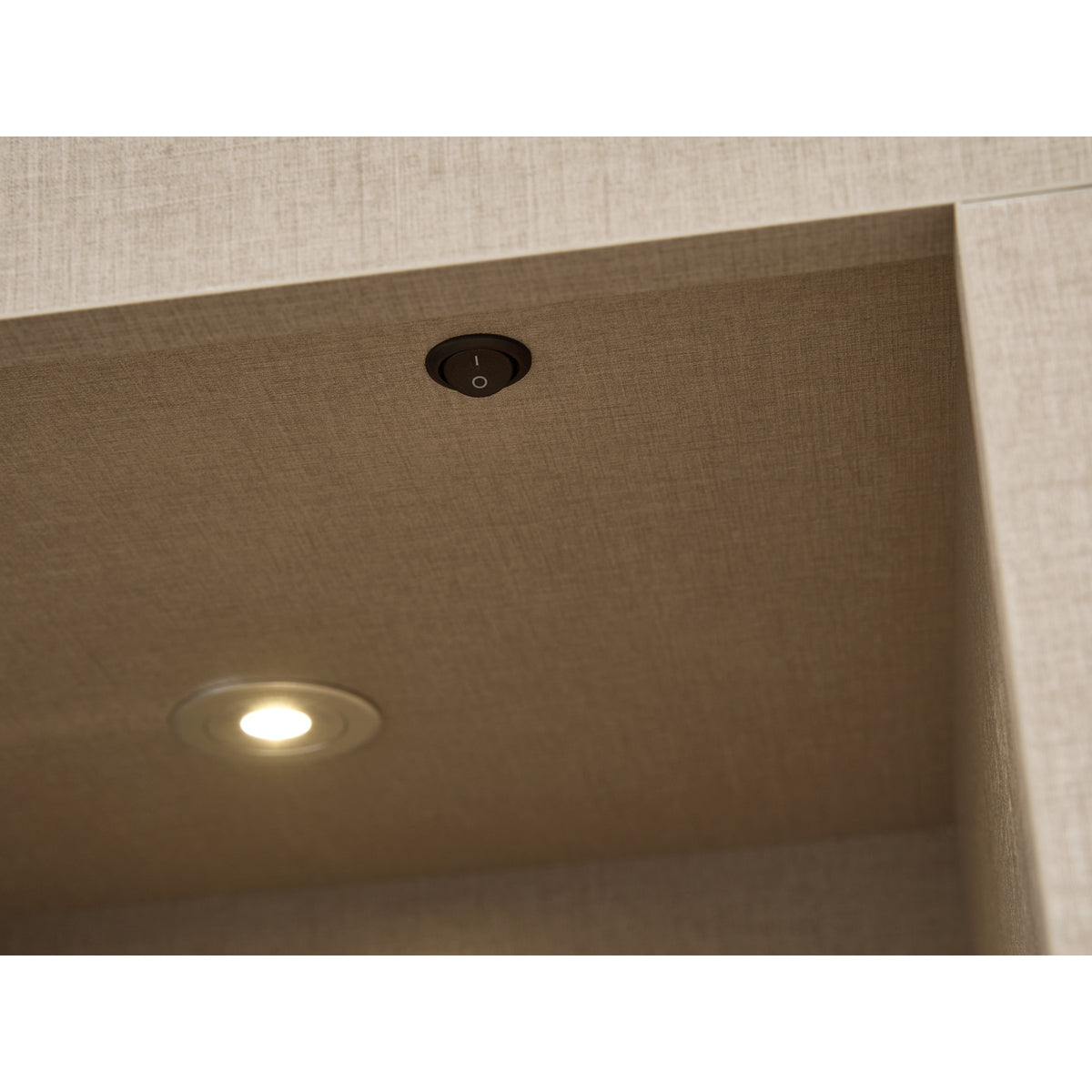 Close up of the downlight and switch in the Acantha chamber kit in linen