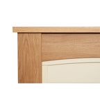 Close-up of the Adam Chilton oak finish mantel above the curved cream back panel