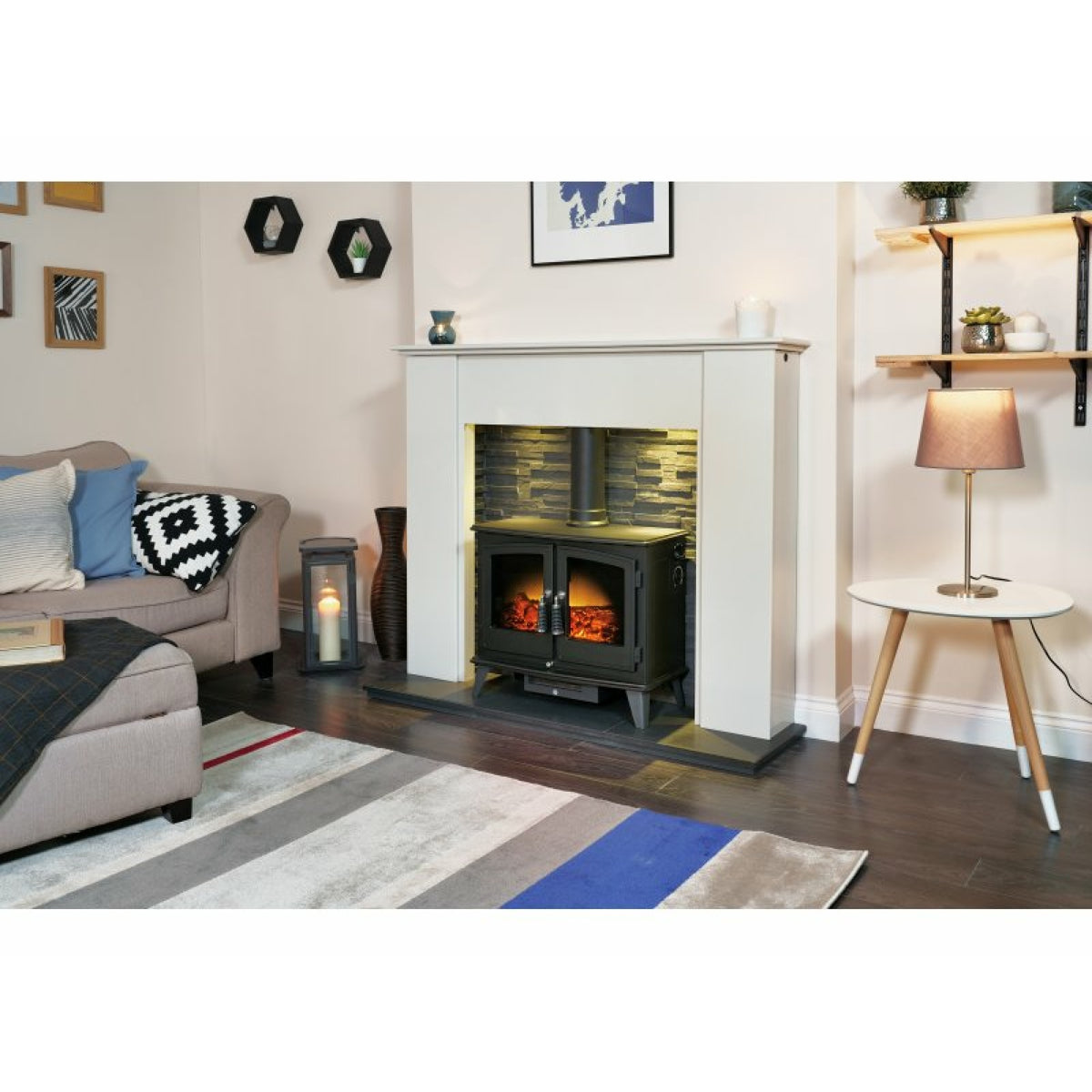 Adam Woodhouse electric stove in black with stove pipe in a fireplace setting