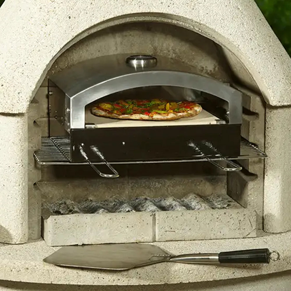 Artisan pizza oven insert baking a pizza inside a Buschbeck masonry barbecue
