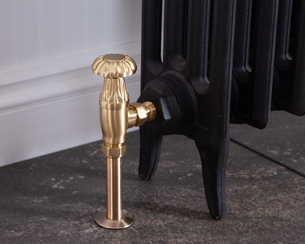 Carron Crocus manual valve in brushed brass installed on a radiator