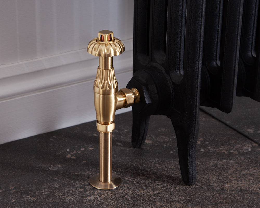 Carron Crocus thermostatic valve in brushed brass installed on a radiator