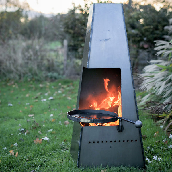 Firepits UK Piazza steel chiminea lit with the swing arm BBQ rack in the opening