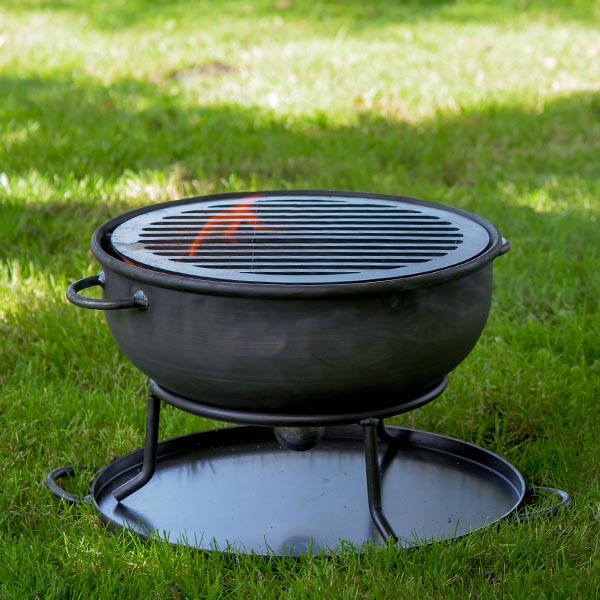Firepits UK 2 in 1 Camping Pit lit with a grill in a garden