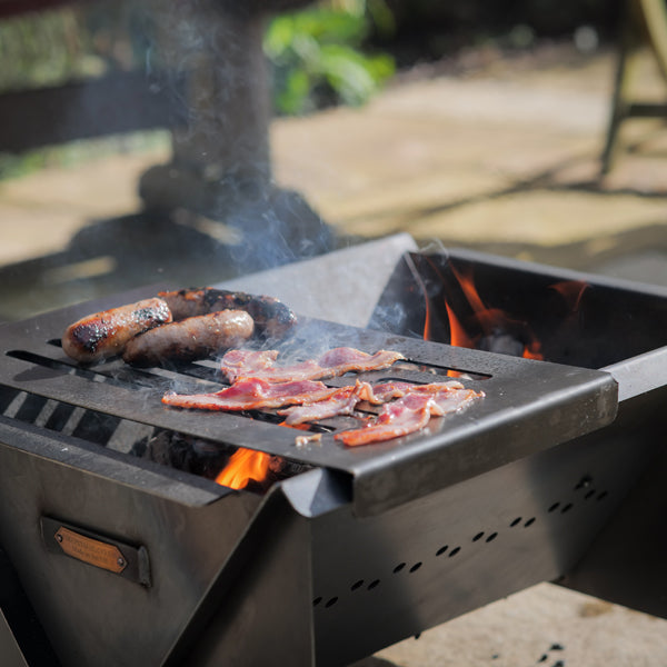Sausages and bacon on the Flat Pack fire pit grill