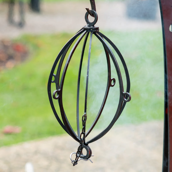 Empty hanging roaster on its chain from a hanging arm