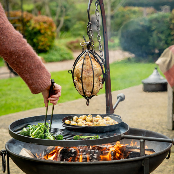 Hanging roaster with potatoes and broccoli over a Plain Jane fire pit