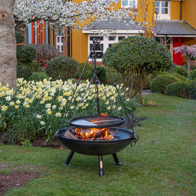 Tripod cooking rack sitting on a Celeste fire pit