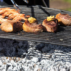 Pork cooking on a half moon all bar rack