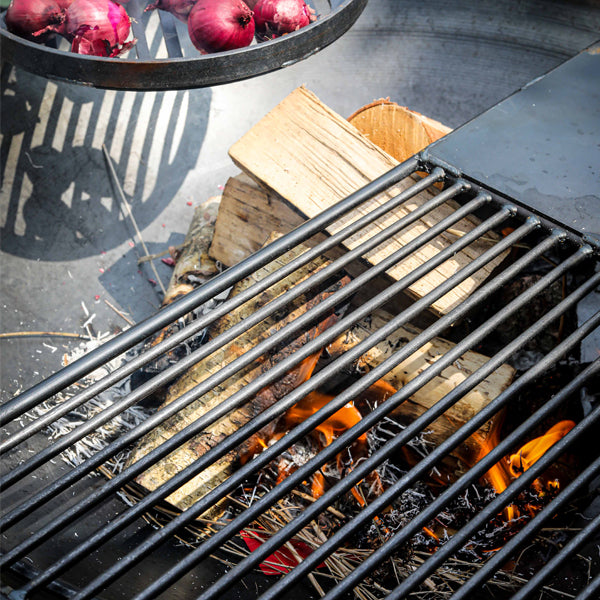 Half moon plate and bar rack cooking over a fire pit