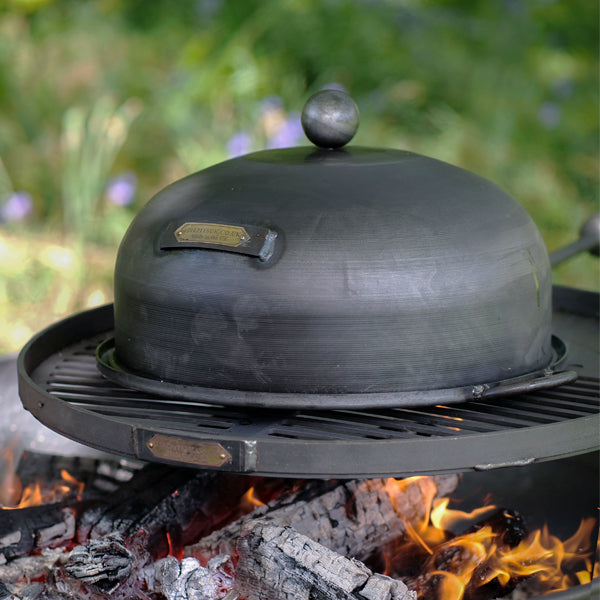 Firepits UK roasting oven on a swing arm BBQ rack over a lit fire pit