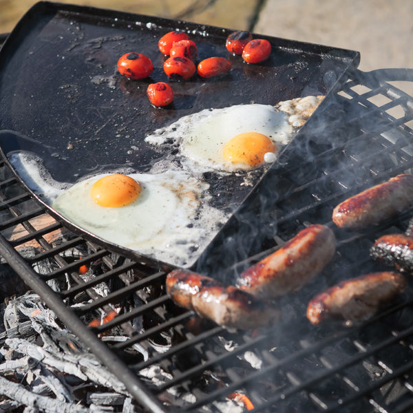 Breakfast cooking on a hot plate over a half moon mesh BBQ rack