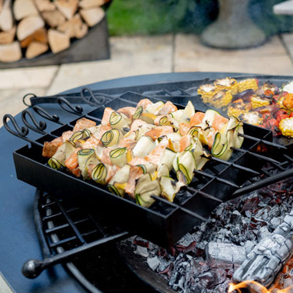 Firepits UK kebab rack with salmon and courgette skewers over a fire pit