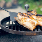 Fire pit paddle turning chicken over a fire