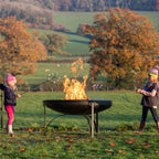 Family toasting marshmallows around a fire pit