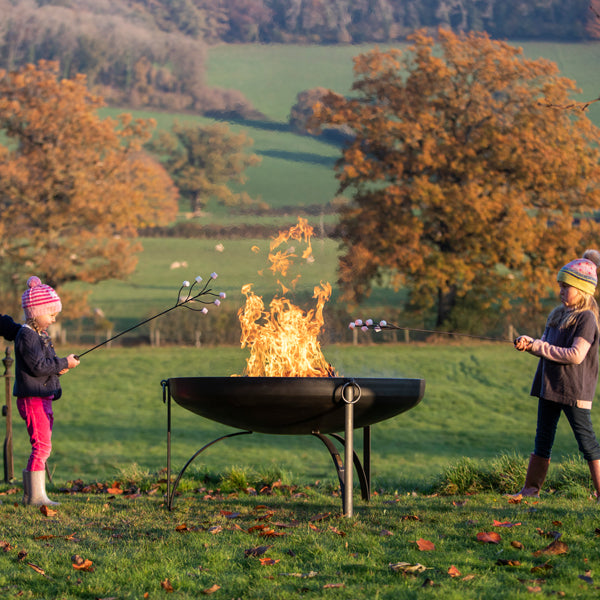 Family toasting marshmallows around a fire pit