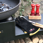 Black fire pit gloves resting on a fire pit
