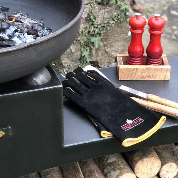 Black fire pit gloves resting on a fire pit
