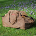 Log carrier bag full of logs in a garden