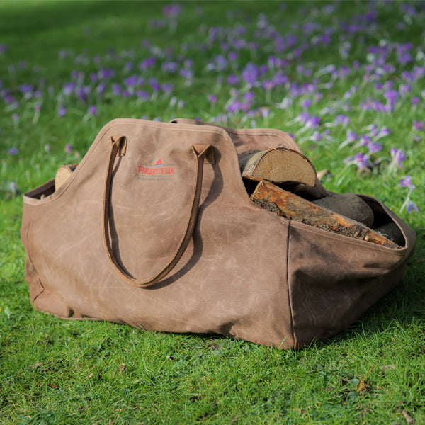 Log carrier bag full of logs in a garden